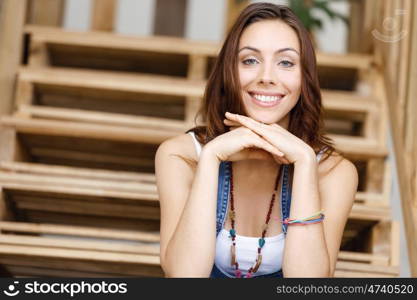 Portrait of young woman sitting at the stairs in office. Portrait of young woman wearing casual clothes sitting at the stairs in office