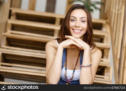 Portrait of young woman sitting at the stairs in office. Portrait of young woman wearing casual clothes sitting at the stairs in office