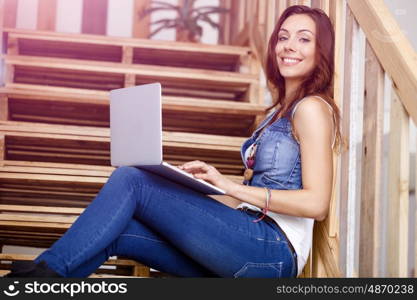 Portrait of young woman sitting at the stairs in office. Portrait of young woman wearing casual clothes sitting at the stairs in office