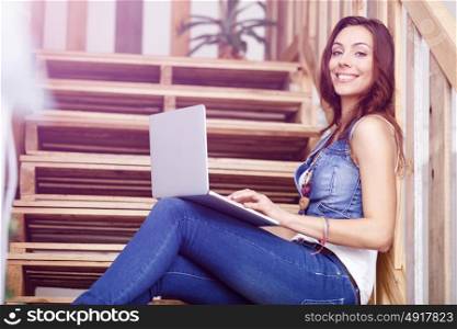 Portrait of young woman sitting at the stairs in office. Portrait of young woman wearing casual clothes sitting at the stairs in office