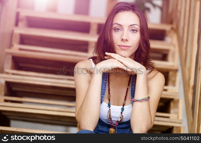 Portrait of young woman sitting at the stairs in office. Portrait of young woman wearing casual clothes sitting at the stairs in office