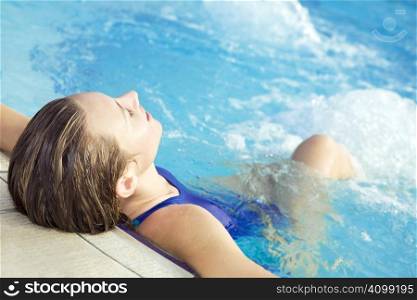 Portrait of young woman sitting in swimming pool
