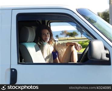 Portrait of young woman sitting in van at beach, Williamstown, Melbourne, Australia