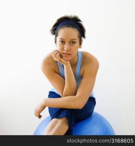 Portrait of young woman sitting on fitness balance ball.