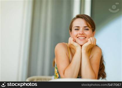 Portrait of young woman sitting on terrace