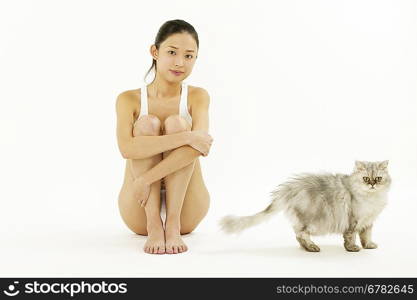 Portrait of young woman sitting with cat