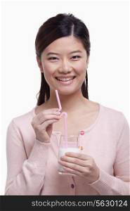Portrait of young woman smiling and drinking a glass of milk