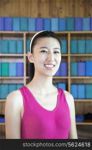 Portrait of young woman smiling in a yoga studio