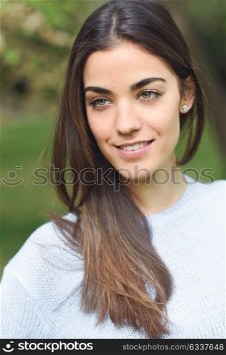 Portrait of young woman smiling in urban background wearing casual clothes