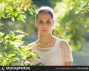 Portrait of young woman standing in foliage