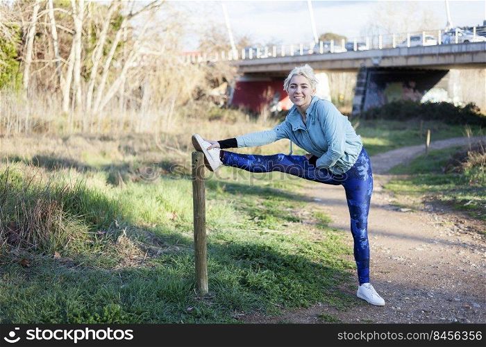 Portrait of young woman stretching and preparing for running.