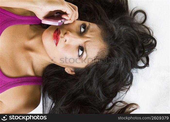 Portrait of young woman talking on pink cell phone