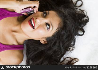 Portrait of young woman talking on pink cell phone