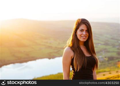 Portrait of young woman, Talybont Reservoir in Glyn Collwn valley, Brecon Beacons, Powys, Wales