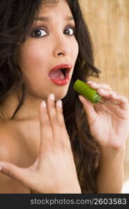 Portrait of young woman tasting very spicy jalapeno