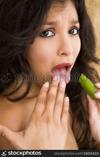 Portrait of young woman tasting very spicy jalapeno