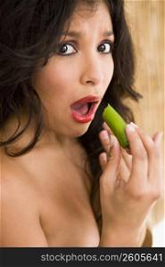 Portrait of young woman tasting very spicy jalapeno
