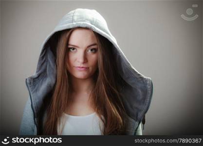 Portrait of young woman teen girl long hair in hooded sweatshirt on gray background