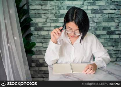 Portrait of young woman thinking while serious working at home with laptop on desk