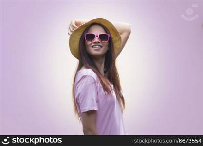 Portrait of young woman wearing hat and sunglasses