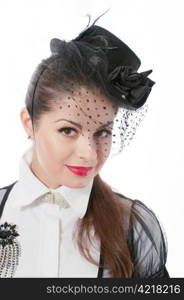 Portrait of young woman wearing the hat with a veil and white blouse with the brooch on her breast