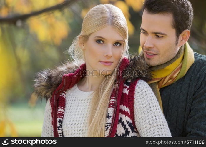 Portrait of young woman with boyfriend in park