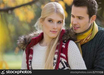 Portrait of young woman with boyfriend in park