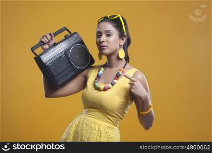 Portrait of young woman with cassette player