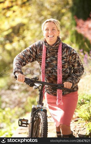 Portrait Of Young Woman With Cycle In Autumn Park