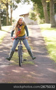 Portrait Of Young Woman With Cycle In Autumn Park