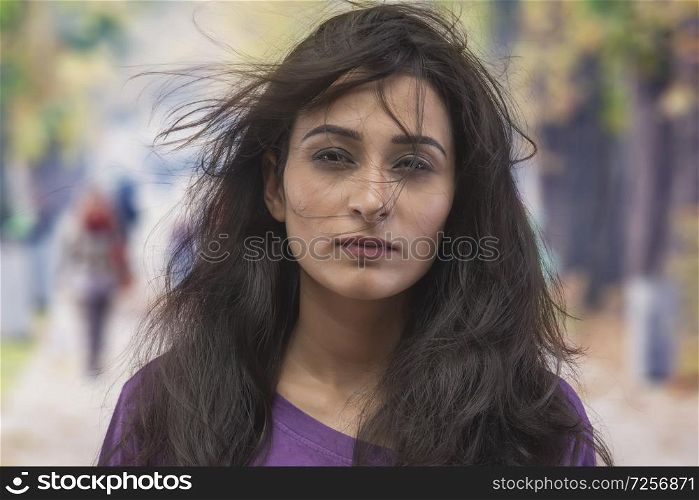 Portrait of young woman with dishevelled hair on the street