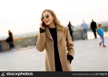 Portrait of young woman with eyeglasses with mobile phone outdoor