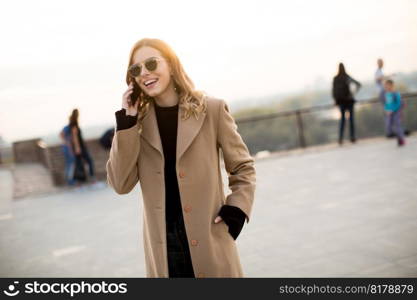 Portrait of young woman with eyeglasses with mobile phone outdoor