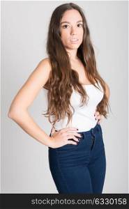 Portrait of young woman with long hair wearing white t-shirt and blue jeans on white background
