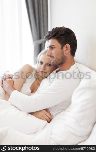 Portrait of young woman with man hugging in hotel room