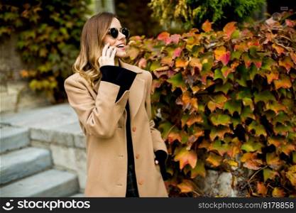 Portrait of young woman with mobile phone outdoor