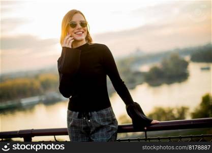 Portrait of young woman with mobile phone outdoor