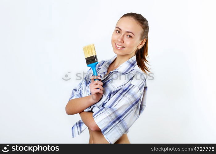 Portrait of young woman with paint brushes
