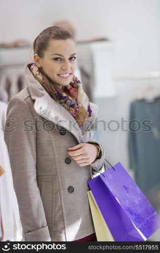 Portrait of young woman with shopping bags in store