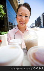 Portrait of young woman with take-away coffees, outdoors