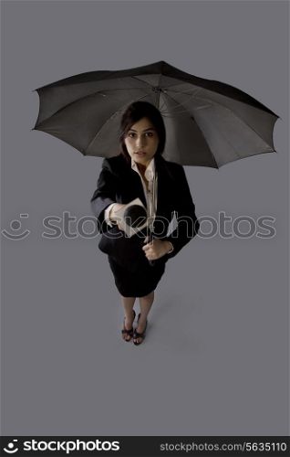 Portrait of young woman with umbrella asking comment