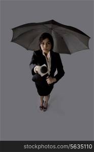 Portrait of young woman with umbrella asking comment
