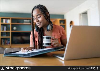 Portrait of young woman working from home with laptop and files. Home office concept. New normal lifestyle.