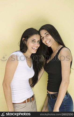 Portrait of young women with long hair against yellow background