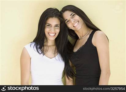 Portrait of young women with long hair against yellow background