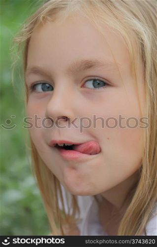 Portrait of younger schoolgirl with put out tongue