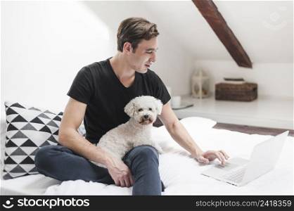 portrait owner with his friendly dog using laptop home