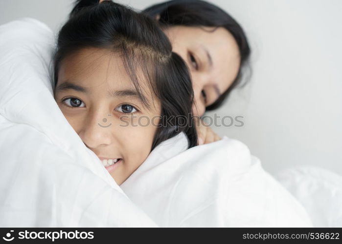 Portrait picture of love family mother and daughter hugging together. Cute girl smile beautiful and happy on bed.