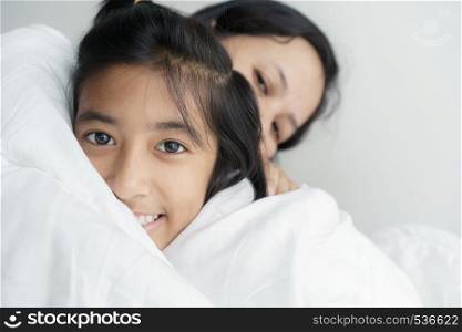 Portrait picture of love family mother and daughter hugging together. Cute girl smile beautiful and happy on bed.