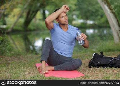 portrait portsman with bottle of water sitting and relaxing outdoors